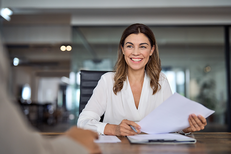 a business woman smiling holding some paper